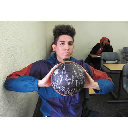 Pyramid project 3, a participant showing off the basketball they decorated